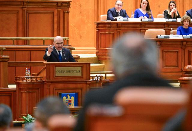 Romanian Prime Minister Ilie Bolojan addresses the Parliament in Bucharest on May 5, 2026. Romania's parliament on May 5 will vote on a motion of no confidence that could oust Premier Bolojan, deepening political turmoil in the country, an EU and NATO member bordering Ukraine. Romania's biggest party, the Social Democrats (PSD), quit the government last month and joined forces with the far right to file the motion. (Photo by Daniel MIHAILESCU / AFP)