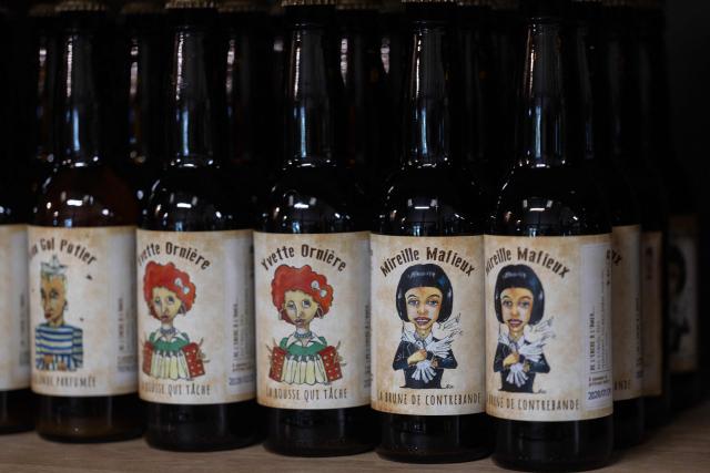 This photograph taken in Bannalec, western France on May 5, 2026 shows bottles of beers named 'Jean Gol Potier', 'Yvette Orniere' and 'Mireille Mafieux', play on words in reference to French fashion designer Jean-Paul Gaultier, French accordionist and pianist Yvette Horner and French singer Mireille Mathieu displayed at the brewery 'Brasserie de l'imprimerie'. Following a formal notice from Yoko Ono, the widow of the Beatles singer, a Breton brewery has sold several thousand bottles of ‘John Lemon’ beer in just a few days – beer it will no longer be able to sell after July 1, 2026, the brewer told AFP on May 5, 2026. At the end of March, a Dutch law firm served the brewery with a formal notice to cease marketing ‘John Lemon’, failing which it would face having to pay substantial sums to the Yoko Ono Trust, which is responsible for protecting John Lennon’s image. (Photo by Fred TANNEAU / AFP)