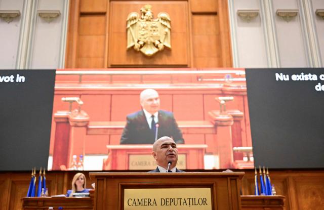 Romanian Prime Minister Ilie Bolojan addresses the Parliament in Bucharest on May 5, 2026. Romania's parliament on May 5 will vote on a motion of no confidence that could oust Premier Bolojan, deepening political turmoil in the country, an EU and NATO member bordering Ukraine. Romania's biggest party, the Social Democrats (PSD), quit the government last month and joined forces with the far right to file the motion. (Photo by Daniel MIHAILESCU / AFP)