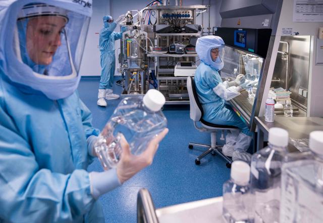 (FILES) Employees in cleanroom suits test the procedures for the manufacturing of the messenger RNA (mRNA) for the Covid-19 vaccine at the new manufacturing site of German company BioNTech on March 27, 2021 in Marburg, central Germany. The biotechnology company Biontech plans to close several sites. "Biontech intends to shut down its production facilities in Idar-Oberstein, Marburg and Singapore, as well as at CureVacs sites, which could affect a total of up to around 1,860 jobs," the Mainz-based pharmaceutical company announced on May 5, 2026. The move is expected to generate annual savings of around 500 million euros. (Photo by Thomas Lohnes / AFP)