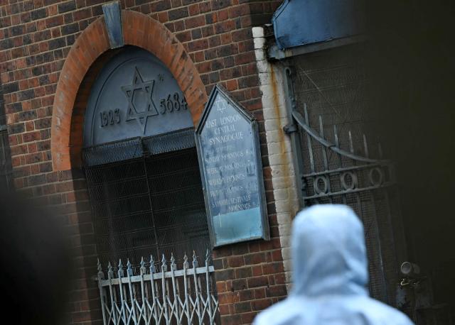 A Police forensics officer works at the scene outside a former Synagogue in Whitechapel district of east London, on May 5, 2026, following a suspected arson attack at the site in the early hours of the morning. London police said on Tuesday May 5, 2026, that they were investigating a new arson incident targeting the Jewish community after a blaze at a former synagogue. The news came as Prime Minister Keir Starmer gathered public figures for talks on a response to what he called a "crisis" after a series of antisemitic attacks. (Photo by JUSTIN TALLIS / AFP)