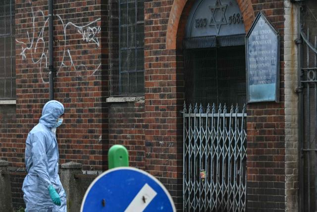 A police forensics officer works at the scene outside a former synagogue in Whitechapel district of east London, on May 5, 2026, following a suspected arson attack at the site in the early hours of the morning. London police said on May 5 that they were investigating a new arson incident targeting the Jewish community after a blaze at a former synagogue. The news came as Prime Minister Keir Starmer gathered public figures for talks on a response to what he called a "crisis" after a series of antisemitic attacks. (Photo by JUSTIN TALLIS / AFP)