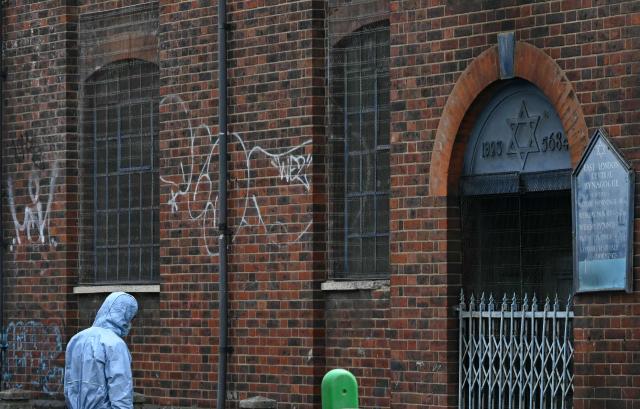 A Police forensics officer works at the scene outside a former Synagogue in Whitechapel district of east London, on May 5, 2026, following a suspected arson attack at the site in the early hours of the morning. London police said on Tuesday May 5, 2026, that they were investigating a new arson incident targeting the Jewish community after a blaze at a former synagogue. The news came as Prime Minister Keir Starmer gathered public figures for talks on a response to what he called a "crisis" after a series of antisemitic attacks. (Photo by JUSTIN TALLIS / AFP)