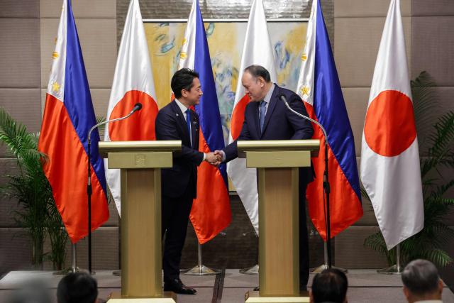 Japan's Defense Minister Shinjiro Koizumi (L) and Philippines' Defense Secretary Gilbert Teodoro Jr. shake hands after a bilateral meeting in Manila on May 5, 2026.  (Photo by MARK CRISTINO / AFP)