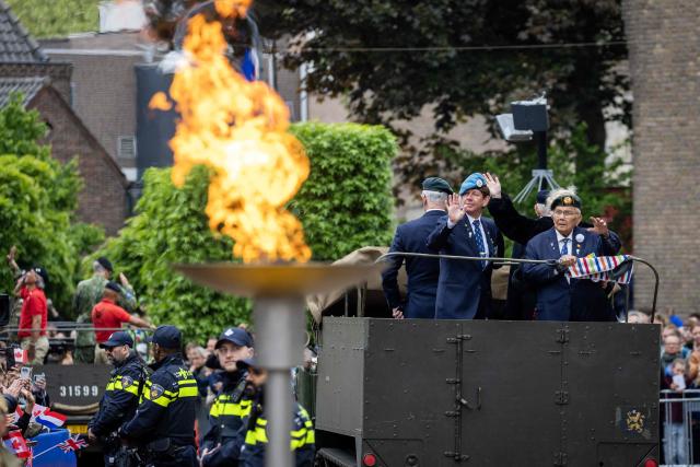 Veterans and soldiers wave during the annual freedom parade with veterans and military personnel as part of the National Liberation Day ceremonies marking the end of the German occupation in 1945, in Wageningen on May 5, 2026. (Photo by Vincent Jannink / ANP / AFP) / Netherlands OUT