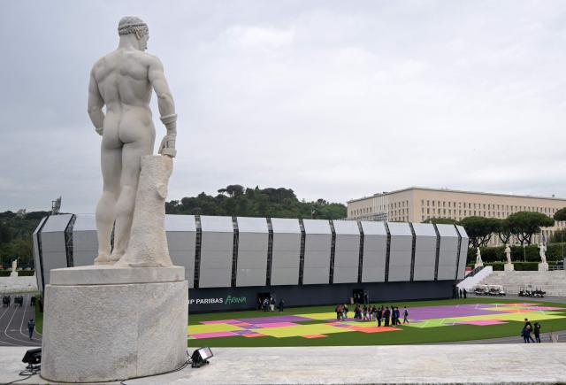 People walk near the "Super Tennis Arena" a temporary tennis court built inside the Marble Stadium (Stadio dei Marmi) for the ATP/WTA Tennis tournament of Rome, on May 5, 2026. (Photo by Tiziana FABI / AFP)