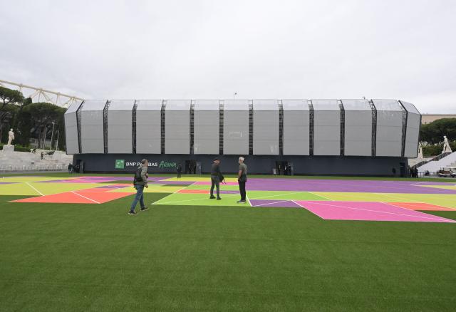 People walk near the "Super Tennis Arena" a temporary tennis court built inside the Marble Stadium (Stadio dei Marmi) for the ATP/WTA Tennis tournament of Rome, on May 5, 2026. (Photo by Tiziana FABI / AFP)