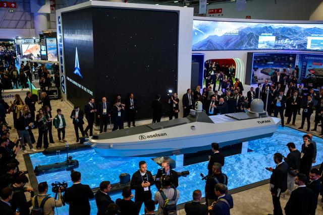 Visitors surround new unmanned naval solutions ''TUFAN and KILIC'' on the stand of Turkish defence company Aselsan during the opening day of the SAHA EXPO 2024, an International Defence and Aerospace exhibition, in Istanbul on May 5, 2026. (Photo by Yasin AKGUL / AFP)