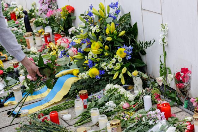 A man places flowers at a makeshift memorial in front of the Paulinum (University Auditorium and St Pauli University Church) in Leipzig, eastern Germany, on May 5, 2026, close to the site where a car ploughed into people on a street, leaving at least two dead and several injured, one day after the incident. A man suspected of ploughing a car into a crowd in the eastern German city of Leipzig, killing two people, recently underwent treatment in a psychiatric hospital, the authorities said on May 5. The German national allegedly drove the vehicle on May 4 at high speed down a main street in the historic centre of the eastern city, leaving two people dead and many others wounded. The 33-year-old suspect was arrested at the scene and officials have said they do not believe he had a political or religious motive. (Photo by Jens SCHLÜTER / AFP)
