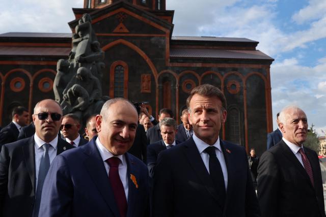 France's President Emmanuel Macron, accompanied by Armenia's Prime Minister Nikol Pashinyan and Armenia's President Vahagn Khachaturyan, walks away after paying tribute at the memorial to the victims of the earthquake of 1988, in Gyumri on May 5, 2026. (Photo by Ludovic MARIN / AFP)