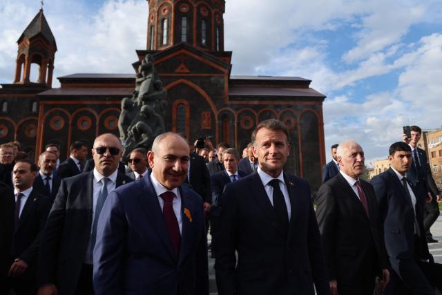 France's President Emmanuel Macron, accompanied by Armenia's Prime Minister Nikol Pashinyan and Armenia's President Vahagn Khachaturyan, walks away after paying tribute at the memorial to the victims of the earthquake of 1988, in Gyumri on May 5, 2026. (Photo by Ludovic MARIN / AFP)