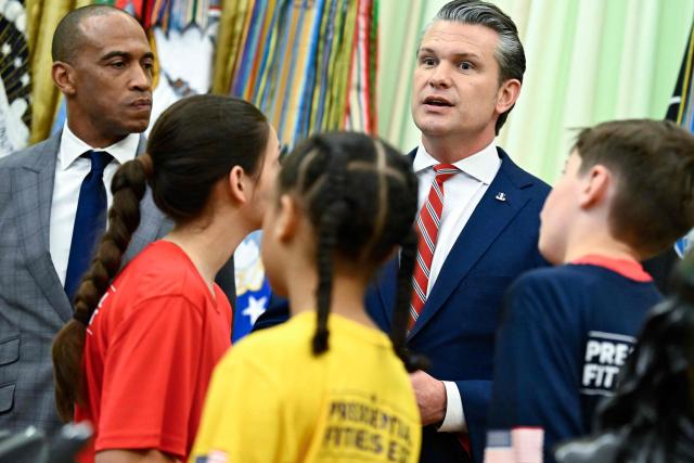 (L/R) US Secretary of Housing and Urban Development Scott Turner looks on as US Secretary of Defense Pete Hegseth speaks before President Donald Trump signs a proclamation to revive the Presidential Fitness Test Award, a competitive school-based fitness program, in the Oval Office of the White House in Washington, DC on May 5, 2026. (Photo by Kent NISHIMURA / AFP)