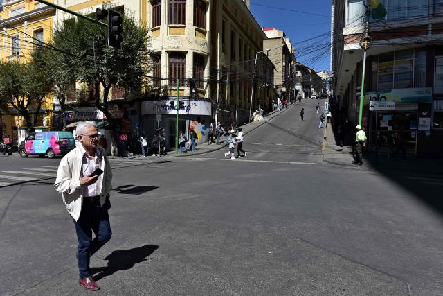 A man crosses an almost empty street during a 24-hour transport strike called by the Bolivian Drivers’ Confederation in protest for the bad quality of oil, in La Paz on May 5, 2026. Drivers demand financial compensation from the government for the damage caused to their vehicles. (Photo by Jorge BERNAL / AFP)