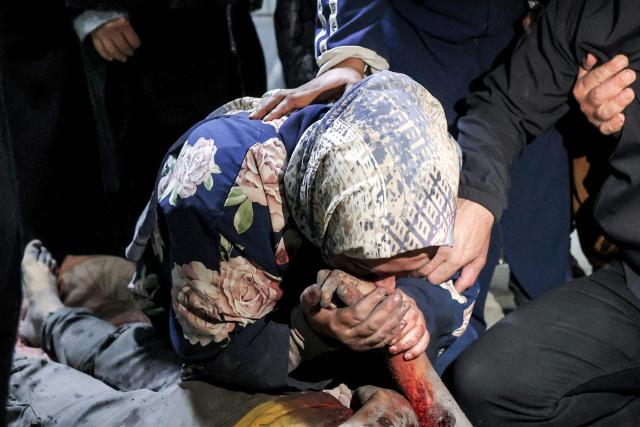 EDITORS NOTE: Graphic content / A woman mourns over the body of Palestinian child Mahmoud Sahwil, 14, who was killed during an Israeli strike on a police station in the Sheikh Radwan neighbourhood, as the body lies at the morgue at Shifa Hospital in Gaza City on May 5, 2026. (Photo by Omar AL-QATTAA / AFP)
