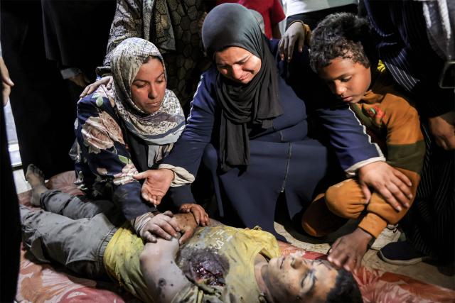 EDITORS NOTE: Graphic content / Relatives mourn over the body of Palestinian child Mahmoud Sahwil, 14, who was killed during an Israeli strike on a police station in the Sheikh Radwan neighbourhood, as the body lies at the morgue at Shifa Hospital in Gaza City on May 5, 2026. (Photo by Omar AL-QATTAA / AFP)
