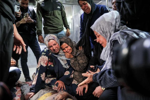 EDITORS NOTE: Graphic content / Relatives mourn over the body of Palestinian child Mahmoud Sahwil, 14, who was killed during an Israeli strike on a police station in the Sheikh Radwan neighbourhood, as the body lies at the morgue at Shifa Hospital in Gaza City on May 5, 2026. (Photo by Omar AL-QATTAA / AFP)