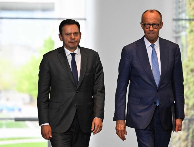 German Chancellor Friedrich Merz (R) and Portuguese Prime Minister Luis Montenegro walk to give a joint press conference at the Chancellery in Berlin on May 5, 2026. (Photo by Tobias SCHWARZ / AFP)