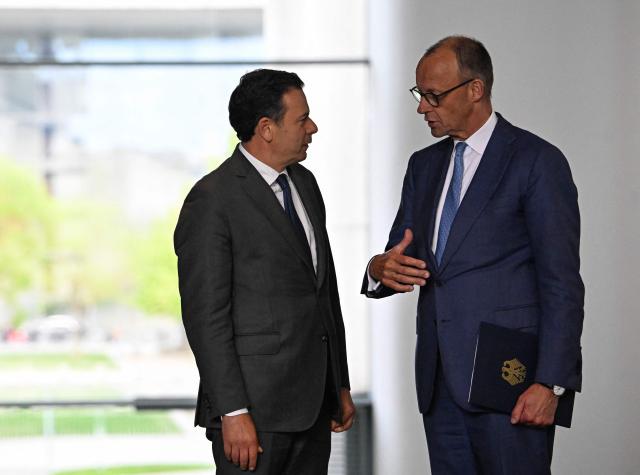 German Chancellor Friedrich Merz (R) and Portuguese Prime Minister Luis Montenegro walk to give a joint press conference at the Chancellery in Berlin on May 5, 2026. (Photo by Tobias SCHWARZ / AFP)
