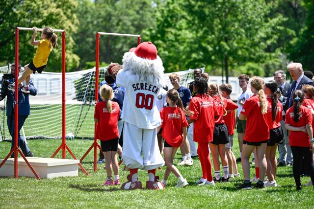 US President Donald Trump (R) watches young student athletes participate in exercise activities on the South Lawn of the White House after President Trump signed a proclamation to revive the Presidential Fitness Test Award, a competitive school-based fitness program, in Washington, DC on May 5, 2026. (Photo by Kent NISHIMURA / AFP)