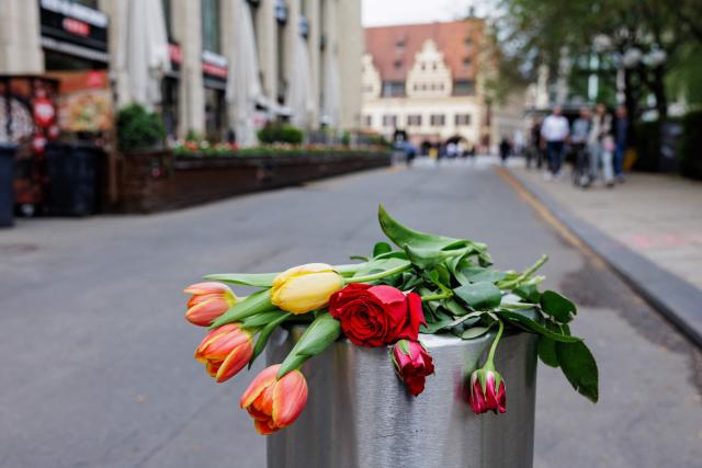 Flowers are left on a street bollard in Leipzig, eastern Germany, close to the site where a car ploughed into people on a street, leaving at least two dead and several injured, one day after the incident, on May 5, 2026. A man suspected of ploughing a car into a crowd in the eastern German city of Leipzig, killing two people, recently underwent treatment in a psychiatric hospital, the authorities said on May 5. The German national allegedly drove the vehicle on May 4 at high speed down a main street in the historic centre of the eastern city, leaving two people dead and many others wounded. The 33-year-old suspect was arrested at the scene and officials have said they do not believe he had a political or religious motive. (Photo by Jens SCHLÜTER / AFP)
