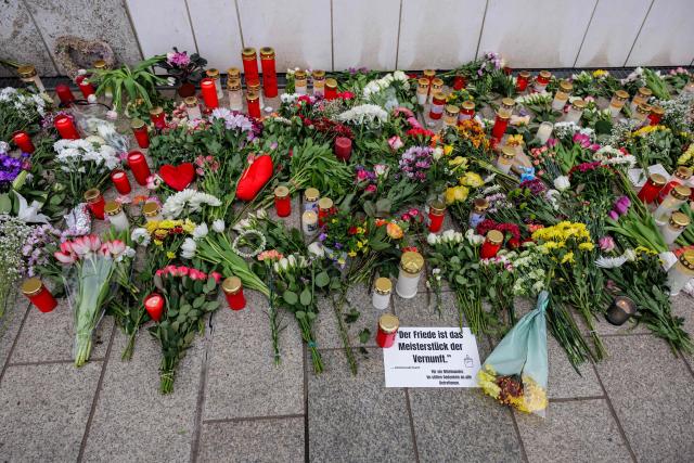 Flowers are placed in front of the Paulinum (University Auditorium and St. Pauli University Church) in Leipzig, eastern Germany, close to the site where a car ploughed into people on a street, leaving at least two dead and several injured, one day after the incident, on May 5, 2026. A man suspected of ploughing a car into a crowd in the eastern German city of Leipzig, killing two people, recently underwent treatment in a psychiatric hospital, the authorities said on May 5. The German national allegedly drove the vehicle on May 4 at high speed down a main street in the historic centre of the eastern city, leaving two people dead and many others wounded. The 33-year-old suspect was arrested at the scene and officials have said they do not believe he had a political or religious motive. (Photo by Jens SCHLÜTER / AFP)
