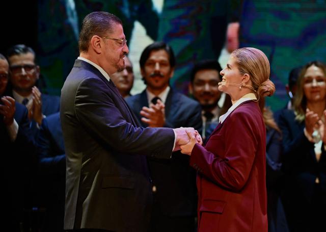 Costa Rica's outgoing President Rodrigo Chaves (L) greets Costa Rica's President-elect Laura Fernandez during the presention of her cabinet in San Jose on May 5, 2026. Costa Rica' outgoing president Rodrigo Chaves will join the cabinet of his successor Laura Fernandez in a position with broad powers that will also grant him immunity from potential legal proceedings. (Photo by Ezequiel BECERRA / AFP)