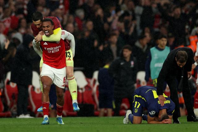 Arsenal's Brazilian defender #06 Gabriel Magalhaes and Arsenal's Spanish goalkeeper #13 Kepa Arrizabalaga celebrate as Atletico Madrid's Argentinian coach Diego Simeone comforts Atletico Madrid's Slovakian defender #17 David Hancko during the UEFA Champions League second-leg semi-final football match between Arsenal and Atletico Madrid at the Emirates Stadium in north London on May 5, 2026. (Photo by Adrian Dennis / AFP)