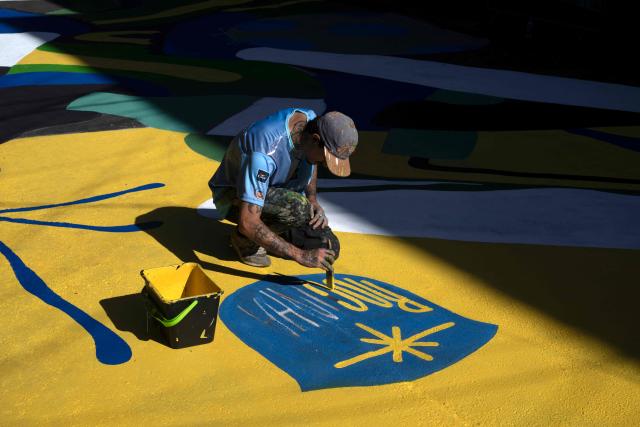 A local artist paints a street ahead of the FIFA World Cup 2026 in the Rocinha favela in Rio de Janeiro, Brazil, on May 5, 2026. (Photo by Pablo PORCIUNCULA / AFP)