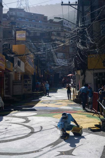 A local artist paints a street ahead of the FIFA World Cup 2026 in the Rocinha favela in Rio de Janeiro, Brazil, on May 5, 2026. (Photo by Pablo PORCIUNCULA / AFP)