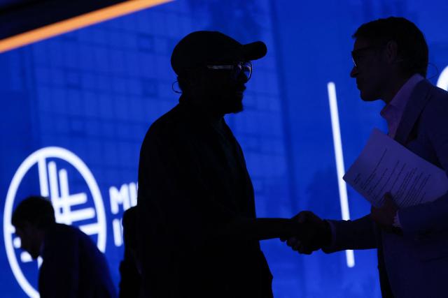 US musician and tech entrepreneur Will.i.am shakes hands with Editorial Director of Bloomberg, Erik Schatzker, during the 29th annual Milken Institute Global Conference at the Beverly Hilton in Beverly Hills, California on May 5, 2026. (Photo by Patrick T. Fallon / AFP)