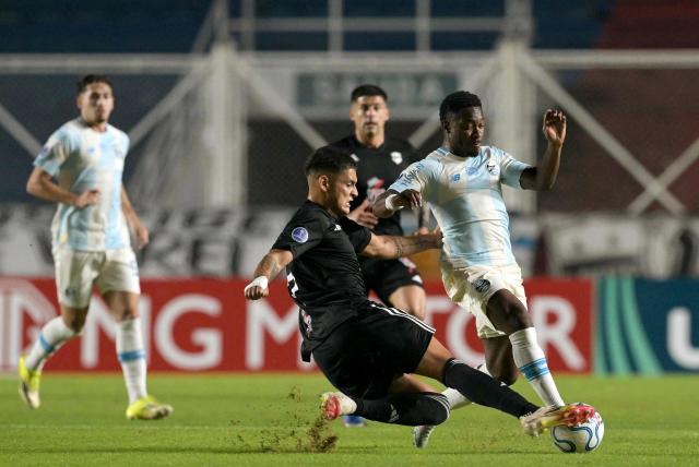 Deportivo Riestra's defender #24 Facundo Mino and Gremio's Belgian midfielder #09 Francis Amuzu fight for the ball during the Copa Sudamericana group stage football match between Argentina's Deportivo Riestra and Brazil's Gremio at the Pedro Bidegain stadium in Buenos Aires on May 5, 2026. (Photo by JUAN MABROMATA / AFP)