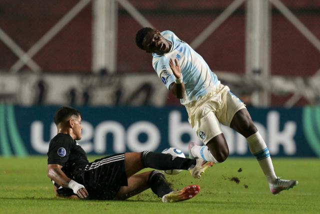 Deportivo Riestra's defender #24 Facundo Mino and Gremio's Belgian midfielder #09 Francis Amuzu fight for the ball during the Copa Sudamericana group stage football match between Argentina's Deportivo Riestra and Brazil's Gremio at the Pedro Bidegain stadium in Buenos Aires on May 5, 2026. (Photo by JUAN MABROMATA / AFP)