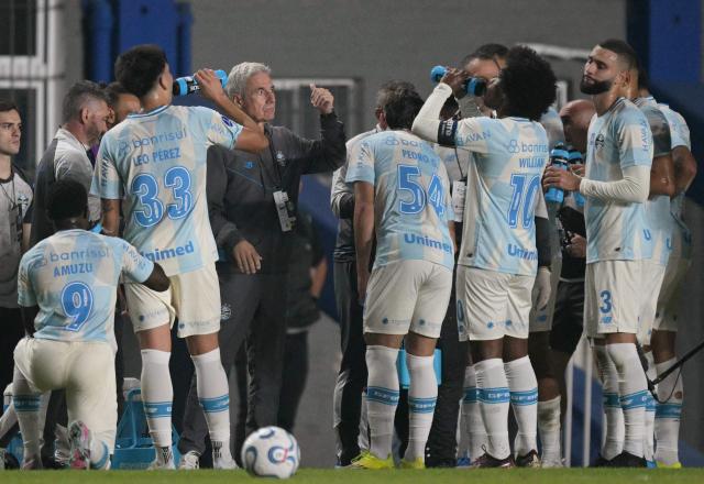 Gremio's Portuguese head coach Luis Castro speaks to his players at the first half cooling break during the Copa Sudamericana group stage football match between Argentina's Deportivo Riestra and Brazil's Gremio at the Pedro Bidegain stadium in Buenos Aires on May 5, 2026. (Photo by JUAN MABROMATA / AFP)