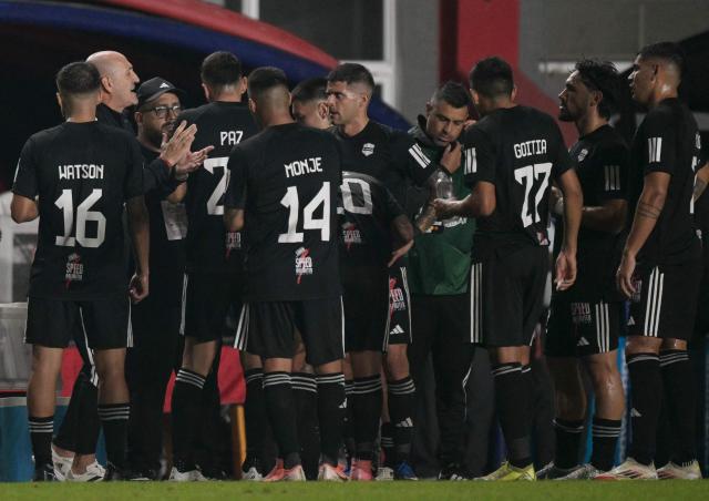 Deportivo Riestra's head coach Guillermo Duro speaks to his players at the first half cooling break during the Copa Sudamericana group stage football match between Argentina's Deportivo Riestra and Brazil's Gremio at the Pedro Bidegain stadium in Buenos Aires on May 5, 2026. (Photo by JUAN MABROMATA / AFP)