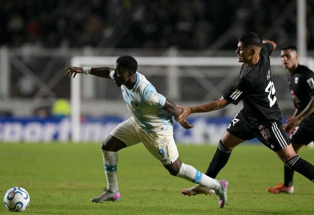 Gremio's Belgian midfielder #09 Francis Amuzu and Deportivo Riestra's defender #24 Facundo Mino fight for the ball during the Copa Sudamericana group stage football match between Argentina's Deportivo Riestra and Brazil's Gremio at the Pedro Bidegain stadium in Buenos Aires on May 5, 2026. (Photo by JUAN MABROMATA / AFP)