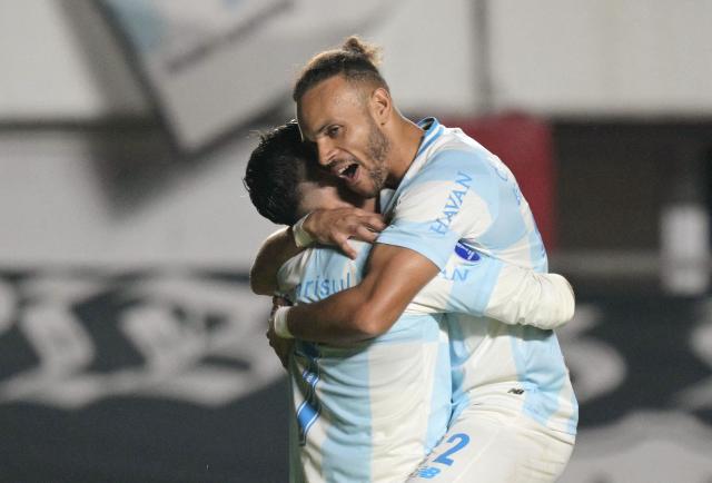 Gremio's Danish forward #22 Martin Braithwaite (R) celebrates after scoring his team's third goal with teammate Gremio's forward #07 Cristian Pavon during the Copa Sudamericana group stage football match between Argentina's Deportivo Riestra and Brazil's Gremio at the Pedro Bidegain stadium in Buenos Aires on May 5, 2026. (Photo by JUAN MABROMATA / AFP)