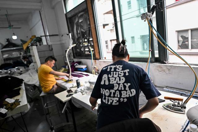 This picture taken on April 27, 2026 shows employees working in a clothing sewing workshop in an urban village in Guangzhou, in southern China's Guangdong province. Vacuum cleaners and vapes could get more expensive if the Iran war drags on for much longer, Chinese factory owners and traders warn, as the world's manufacturing hub reels from "crazy" costs. (Photo by Pedro PARDO / AFP) / To go with 'CHINA-IRAN-MANUFACTURING-TRADE-PLASTIC,FOCUS' by Mary YANG and Tommy WANG