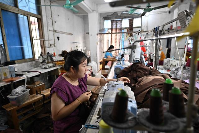 This picture taken on April 27, 2026 shows employees working in a clothing sewing workshop in an urban village in Guangzhou, in southern China's Guangdong province. Vacuum cleaners and vapes could get more expensive if the Iran war drags on for much longer, Chinese factory owners and traders warn, as the world's manufacturing hub reels from "crazy" costs. (Photo by Pedro PARDO / AFP) / To go with 'CHINA-IRAN-MANUFACTURING-TRADE-PLASTIC,FOCUS' by Mary YANG and Tommy WANG