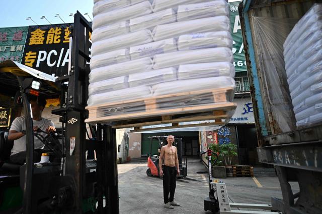 This picture taken on April 29, 2026 shows employees unloading bales from a truck at the Zhangmutou Plastic Raw Material Market in Dongguan, in southern China's Guangdong province. Vacuum cleaners and vapes could get more expensive if the Iran war drags on for much longer, Chinese factory owners and traders warn, as the world's manufacturing hub reels from "crazy" costs. (Photo by Pedro PARDO / AFP) / To go with 'CHINA-IRAN-MANUFACTURING-TRADE-PLASTIC,FOCUS' by Mary YANG and Tommy WANG