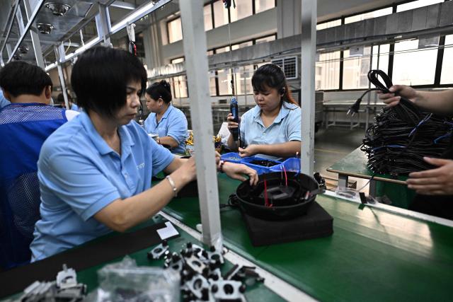 This picture taken on April 28, 2026 shows employees working on the vacuum cleaner production line at the Rimoo Electrical Appliance Tech Company in Foshan, in southern China's Guangdong province. Vacuum cleaners and vapes could get more expensive if the Iran war drags on for much longer, Chinese factory owners and traders warn, as the world's manufacturing hub reels from "crazy" costs. (Photo by Pedro PARDO / AFP) / To go with 'CHINA-IRAN-MANUFACTURING-TRADE-PLASTIC,FOCUS' by Mary YANG and Tommy WANG