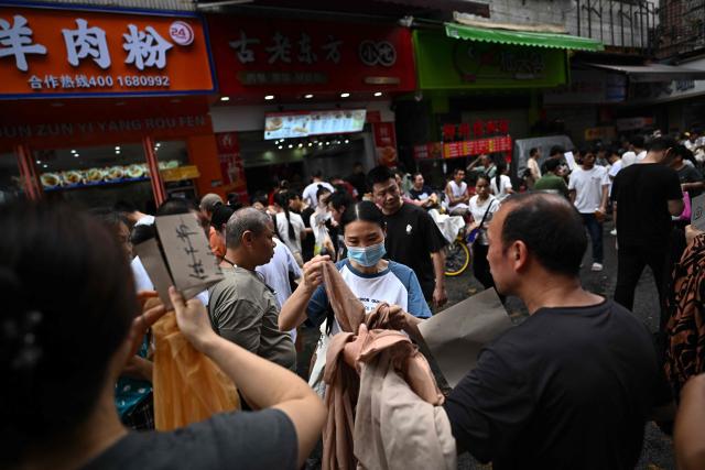 This picture taken on April 27, 2026 shows job-seeking labourers and recruiters from clothing factories on a street in an urban village in Guangzhou, in southern China's Guangdong province. Vacuum cleaners and vapes could get more expensive if the Iran war drags on for much longer, Chinese factory owners and traders warn, as the world's manufacturing hub reels from "crazy" costs. (Photo by Pedro PARDO / AFP) / To go with 'CHINA-IRAN-MANUFACTURING-TRADE-PLASTIC,FOCUS' by Mary YANG and Tommy WANG