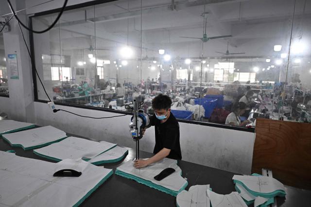 TOPSHOT - This picture taken on April 27, 2026 shows employees working in a clothing sewing workshop in an urban village in Guangzhou, in southern China's Guangdong province. Vacuum cleaners and vapes could get more expensive if the Iran war drags on for much longer, Chinese factory owners and traders warn, as the world's manufacturing hub reels from "crazy" costs. (Photo by Pedro PARDO / AFP) / To go with 'CHINA-IRAN-MANUFACTURING-TRADE-PLASTIC,FOCUS' by Mary YANG and Tommy WANG