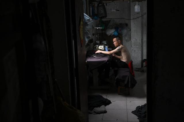 This picture taken on April 27, 2026 shows a man working in a clothing sewing workshop in an urban village in Guangzhou, in southern China's Guangdong province. Vacuum cleaners and vapes could get more expensive if the Iran war drags on for much longer, Chinese factory owners and traders warn, as the world's manufacturing hub reels from "crazy" costs. (Photo by Pedro PARDO / AFP) / To go with 'CHINA-IRAN-MANUFACTURING-TRADE-PLASTIC,FOCUS' by Mary YANG and Tommy WANG