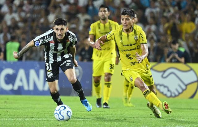Santos' Argentine defender #31 Gonzalo Escobar and Recoleta's midfielder #07 Ronal Dominguez fight for the ball during the Copa Sudamericana group stage football match between Paraguay's Deportivo Recoleta and Brazil's Santos at the Rio Parapiti stadium in Pedro Juan Caballero, Paraguay, on May 5, 2026. (Photo by DANIEL DUARTE / AFP)