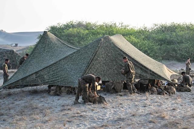 Soldiers rest before the maritime strike of Balikatan exercise between US, Australian, Filipino and Japanese troops in Paoay, Ilocos Norte on May 6, 2026. (Photo by Jam STA ROSA / AFP)