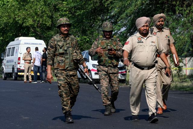 Indian Army and Punjab police personnel walk near the site of a blast, the night after the explosion at the Army cantonment area on the outskirts of Amritsar on May 6, 2026. (Photo by Narinder NANU / AFP)