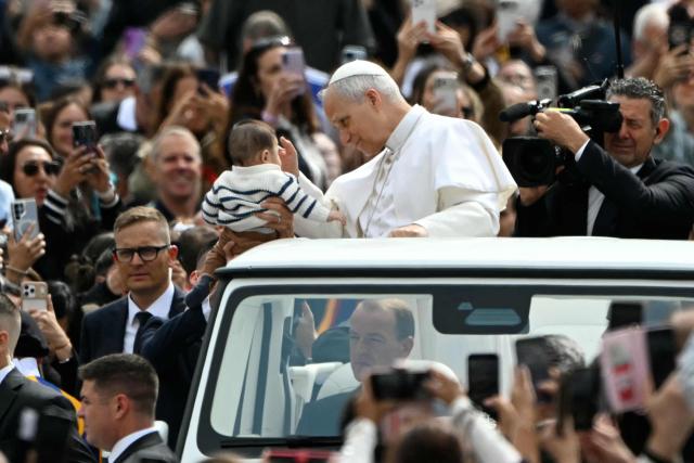 Pope Leo XIV blesses a baby during the weekly general audience at St Peter's Square in The Vatican on May 6, 2026. (Photo by Andreas SOLARO / AFP)