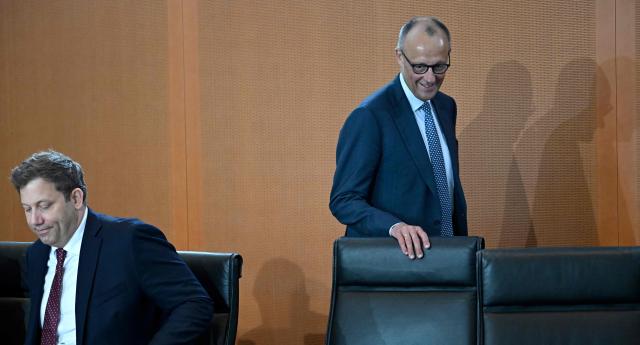 German Chancellor Friedrich Merz (R) walks past German Finance Minister and Vice Chancellor Lars Klingbeil as he arrives for the weekly meeting of the German cabinet at the chancellery in Berlin on May 6, 2026. (Photo by Tobias SCHWARZ / AFP)