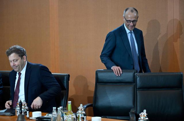 German Chancellor Friedrich Merz walks past German Finance Minister and Vice Chancellor Lars Klingbeil as he arrives for the weekly meeting of the German cabinet at the chancellery in Berlin on May 6, 2026. (Photo by Tobias SCHWARZ / AFP)