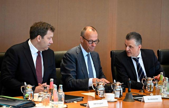 German Chancellor Friedrich Merz (C) sits between German Finance Minister and Vice Chancellor Lars Klingbeil (L) and Chief of Staff and Minister for Special Tasks Thorsten Frei (R) as they prepare for the weekly meeting of the German cabinet at the chancellery in Berlin on May 6, 2026. (Photo by Tobias SCHWARZ / AFP)